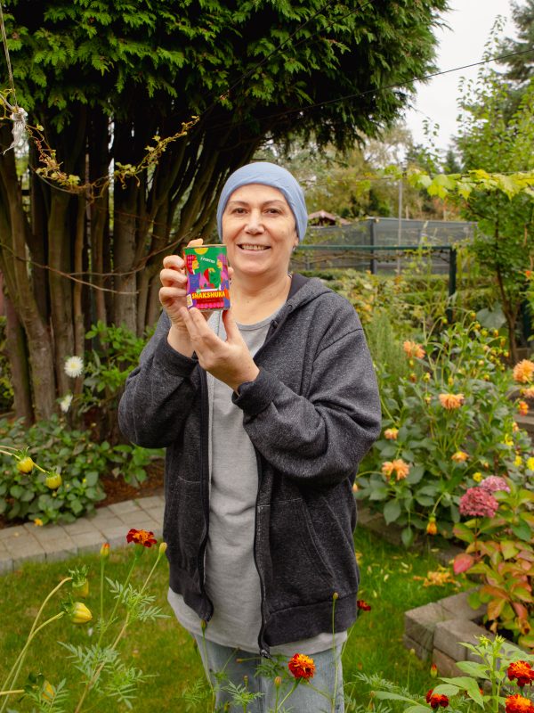 Mixblik vrouwlijke medewerker Selda in haar tuin met Mixblik Linzensoep blik in hand.
